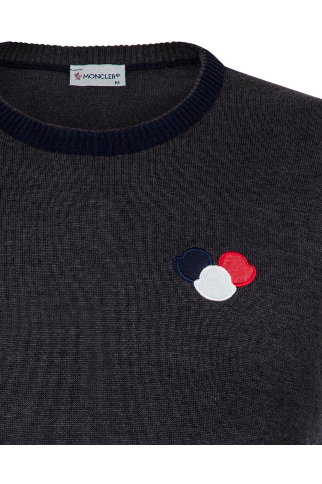 Dark gray Moncler sweater with ribbed collar and tri-color logo patch in navy, white, and red